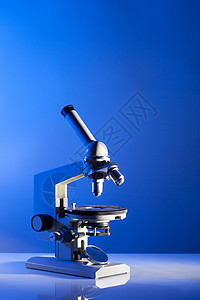 实验室用蓝光桌子上的显微镜显微镜背景图片