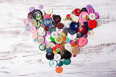 五颜六色的纽扣老式木桌上的心形五颜六色的纽扣图片