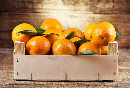 木制背景木箱中的新鲜橘子图片
