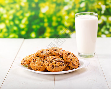 木制桌子上的饼干杯牛奶图片