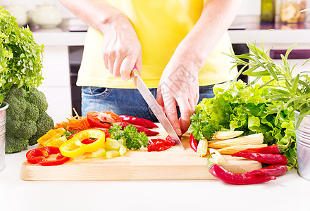 女的手厨房的木板上准备蔬菜沙拉图片