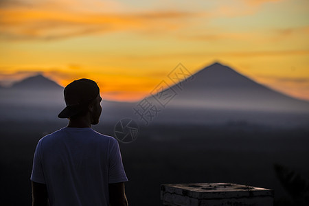 人与火山日出时背景,巴厘岛,印度尼西亚图片