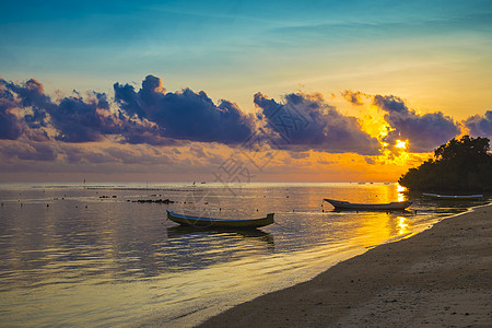 印度尼西亚巴厘岛渔民长尾船的日落场景图片