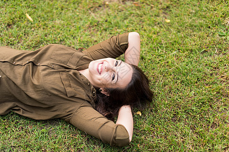 微笑的女人躺草地上放松图片