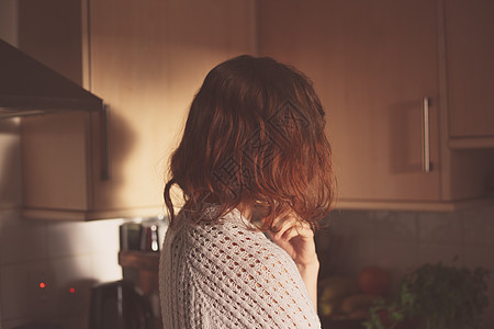 女人站她的厨房里思考图片