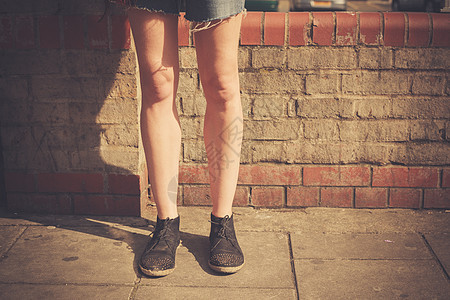特写位轻女子的腿,因为她站街上个阳光明媚的日子图片