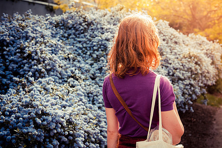 一个年轻的阳光明媚的日子,带着购物袋的轻女人走街上图片