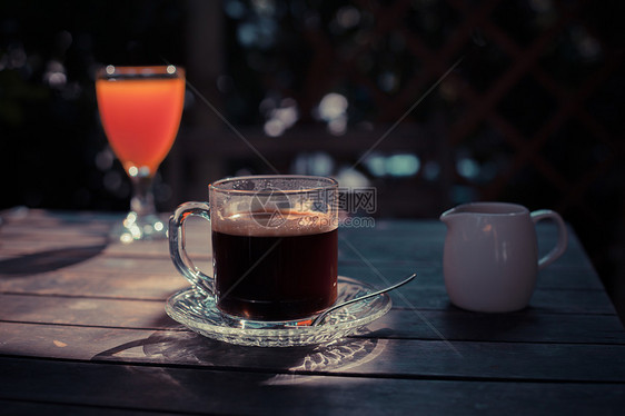 阳光下的张桌子,杯咖啡杯果汁图片