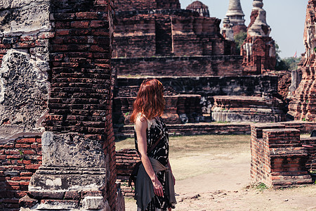 一个年轻女子正探索座佛教寺庙城市的古老废墟图片