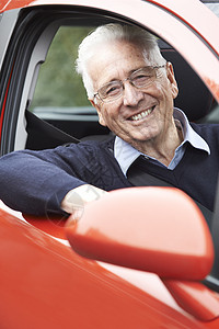 微笑的老人驾驶汽车的肖像高清图片
