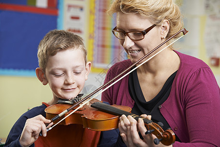 老师音乐课上帮助学生拉小提琴图片