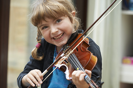 轻女孩学拉小提琴的肖像图片