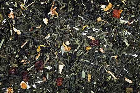 质地干燥的绿茶与花瓣的花果紧密相连图片