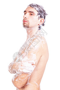 轻的男子泡沫中洗澡,美丽的身体被隔离白色的背景上图片