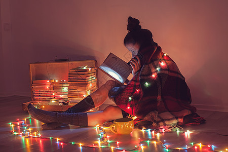 寒冷的天气里,女孩家毯子下看书图片