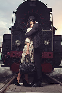 火车头背景下火车站分手可爱的夫妇图片