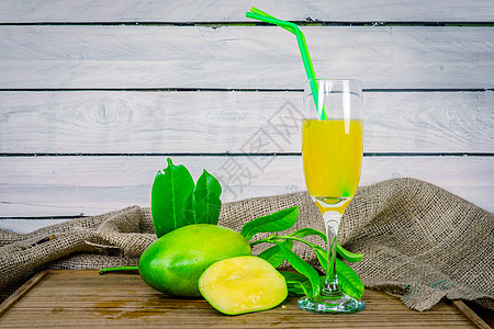 木制桌子上的绿色芒果汁背景图片