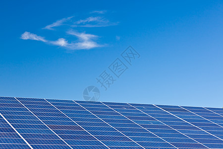光伏电池板深蓝色天空上的太阳能发电厂中的光伏电池板图片