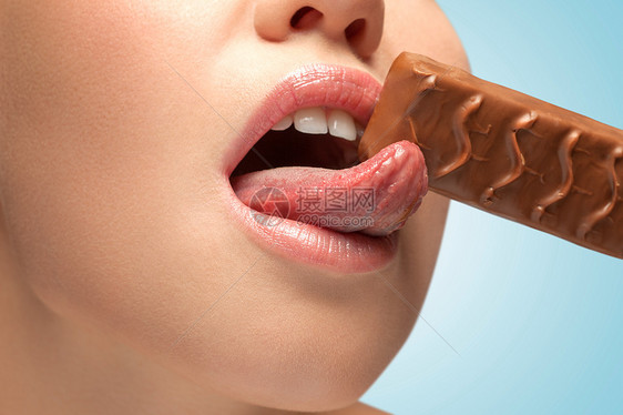 个感的轻女人,美味的嘴唇舔巧克力棒图片