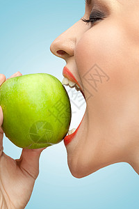 幅女人用张开的嘴咬着个绿色苹果的肖像图片