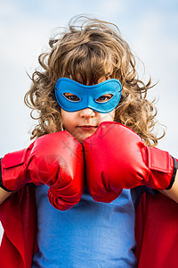 超级英雄的孩子戴着蓝色天空背景的拳击手套女孩权力女权主义图片