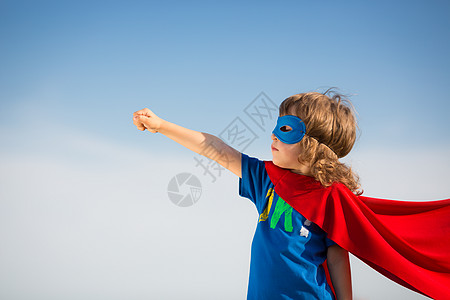 蓝天背景下的超级英雄孩子女孩权力的背景图片