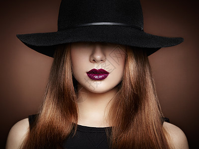 戴帽子的轻漂亮女人的时尚照片女孩摆姿势摄影棚的照片完美的妆容图片