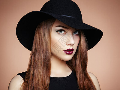 戴帽子的轻漂亮女人的时尚照片女孩摆姿势摄影棚的照片完美的妆容图片