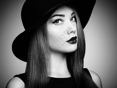 戴帽子的轻漂亮女人的时尚照片女孩摆姿势摄影棚的照片完美的妆容黑白相间图片