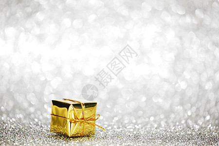 闪闪发光的银色背景上的礼品盒图片