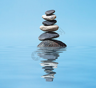 禅宗冥想背景平衡的石头堆叠水中与反射图片