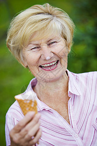 满足兴高采烈的老妇人着冰淇淋笑着图片