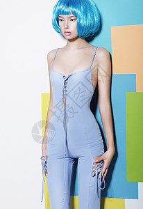 时尚身材匀称的轻女子穿着蓝色工作服创意假发摆姿势背景图片