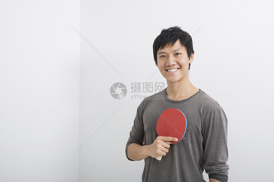 快乐的中男子手持乒乓球桨的肖像图片