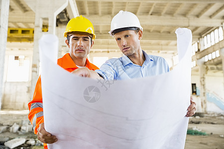 男建筑师建筑工地讨论蓝图图片