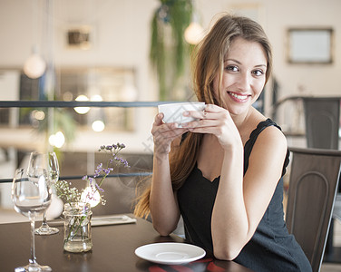 幸福的轻女人餐馆喝咖啡的肖像图片
