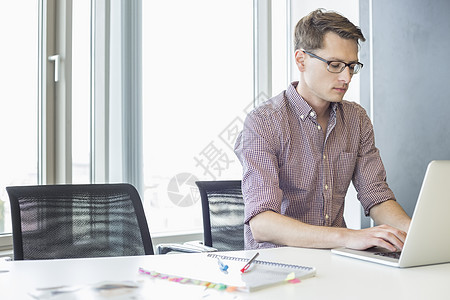 商人创意办公室的桌子上用笔记本电脑图片
