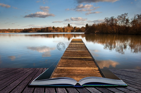 美丽的日落景观的木鱼码头平静的湖上,清晰的倒影魔法书的页中出来图片