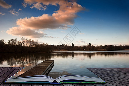 可爱的形象,晚日落的天空,平静的湖泊景观,长长的钓鱼码头充满活力的颜色神奇的书页中出来图片