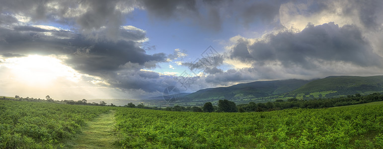 美丽的风景全景,穿过乡村山脉,远处喜怒无常的天空图片