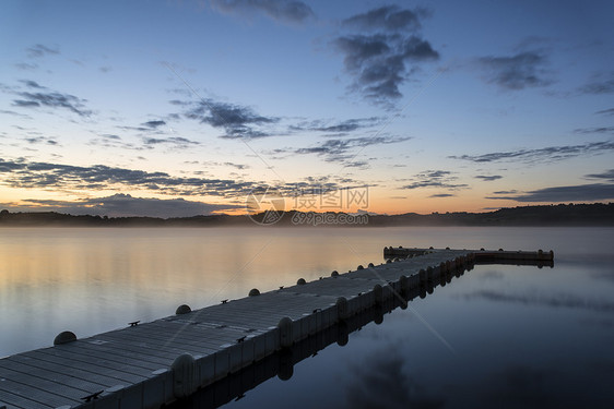 平静湖上码头的日出景观图片