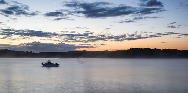 平静湖上船的日出景观图片