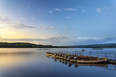 风景日出静止的湖上,船码头上图片