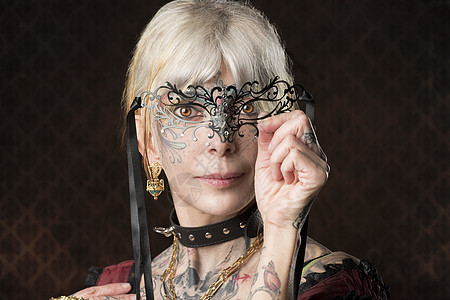 带哥特式服装巴洛克具的纹身女人的特写肖像图片
