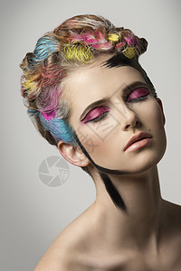女孩摆出轻松的表情创造的美丽肖像与多色彩绘发型疯狂的化妆图片