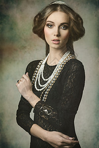 可爱的黑发女孩摆着幻想的肖像,穿着像位古董贵族女士,戴着珍贵的灿烂的皇冠,老式的头发风格灿烂的珠宝图片