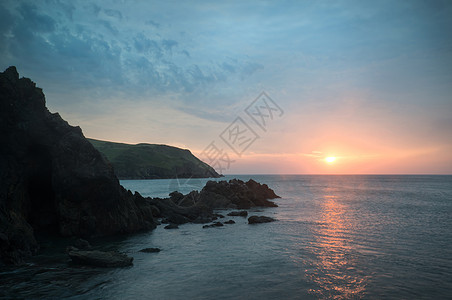 日落景观海景的岩石海岸线希望湾英国图片