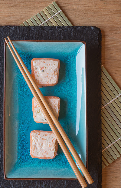 寿司三文鱼包裹盘子里用筷子图片