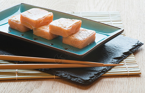 寿司三文鱼包裹盘子里用筷子图片