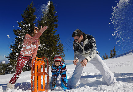 家庭场景冬季快乐的家庭假期的新鲜雪上玩得开心背景